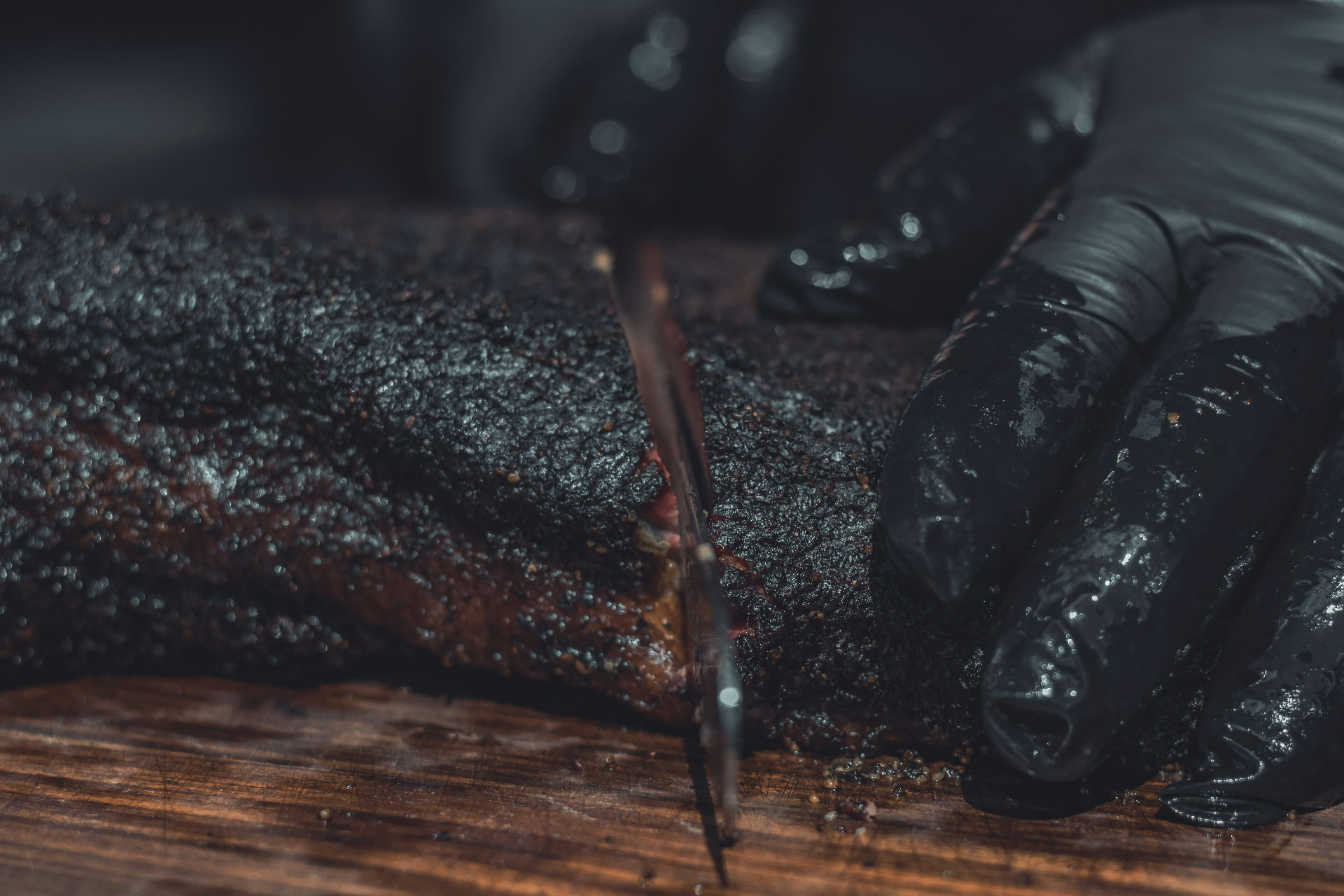 Brisket med mørk bark skjæres opp